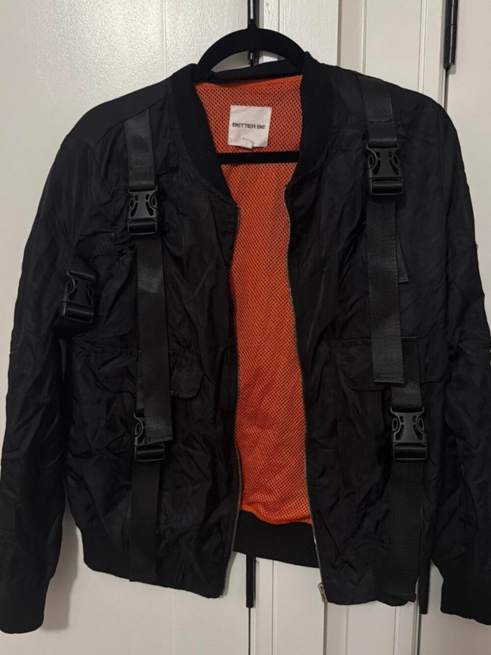 Black bomber jacket with buckles and orange mesh lining